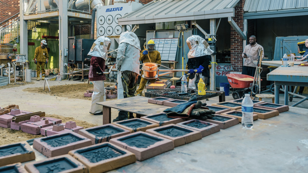 UNCG art students creating iron pour and steamroller press art